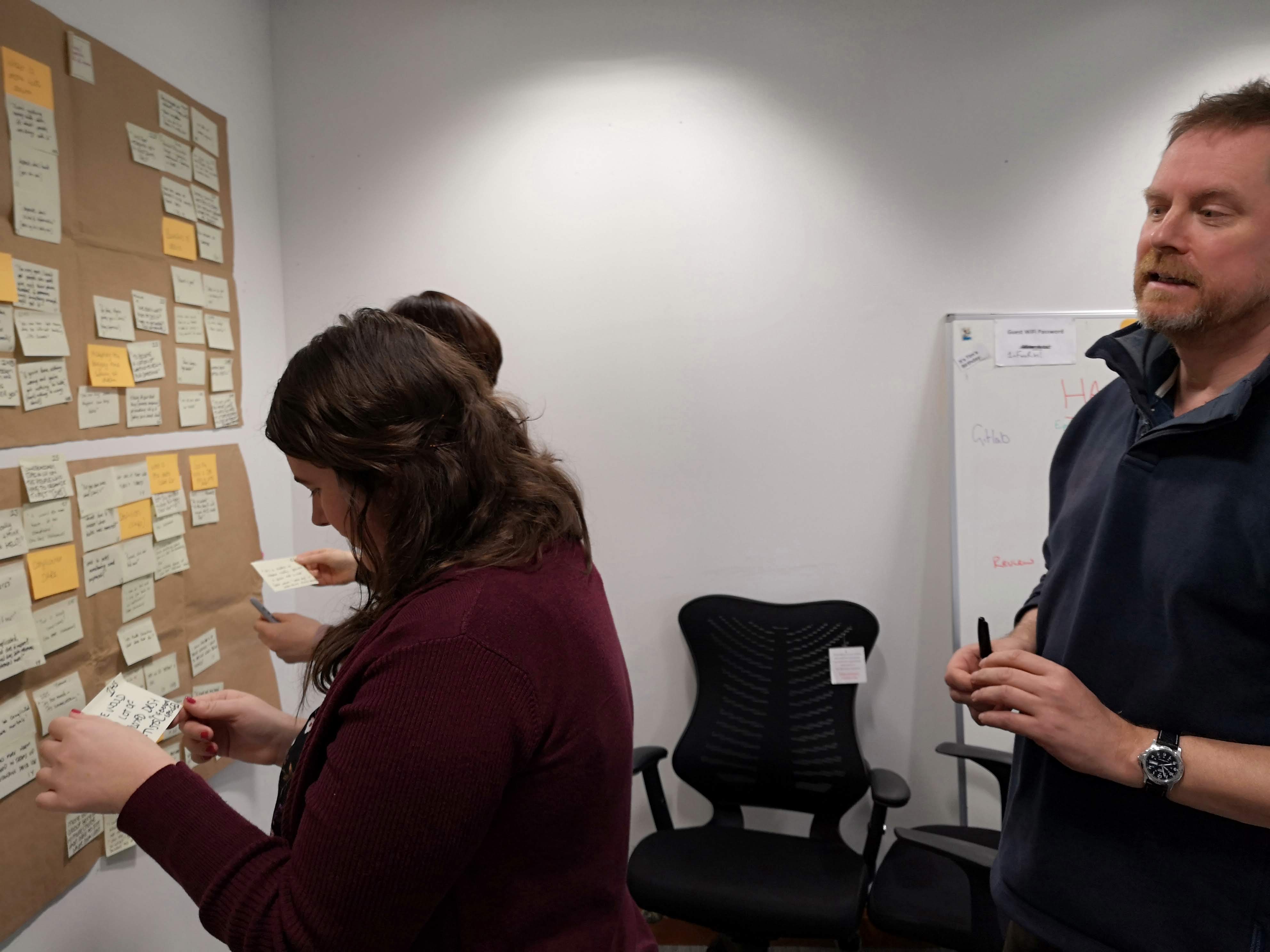 Lucy, Emma and Will looking at sticky notes