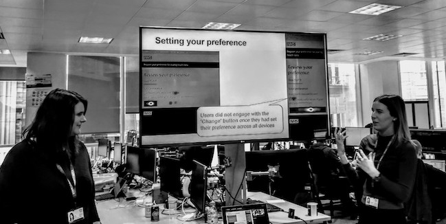 Two user researchers standing in front of a television screen